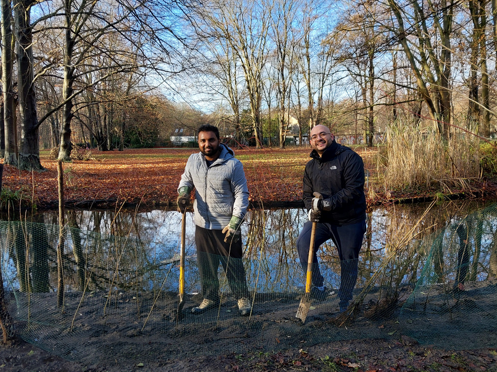 Zwei Männer schaufeln im Tiergarten