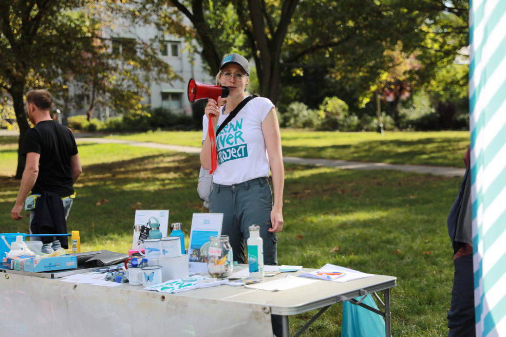 Die zweite Vorsitzende des Clean River Projects, Franziska Braunschädel, spricht durch ein Megafon.