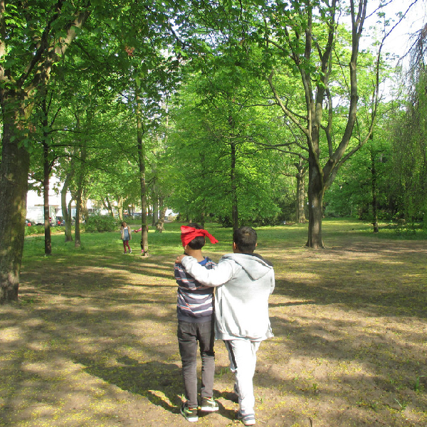 Zwei Kinder sind im lichten Wald unterwegs und erkunden die Natur